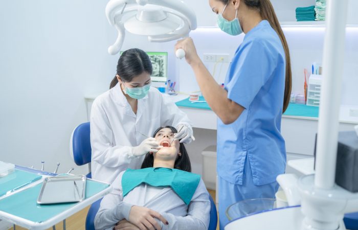 asian-dentist-adjust-dental-surgical-light